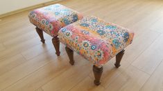 two colorful stools sitting on top of a hard wood floor next to each other