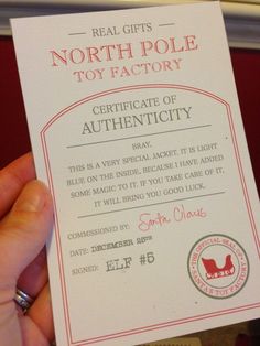 a person holding up a fake north pole toy factory certificate