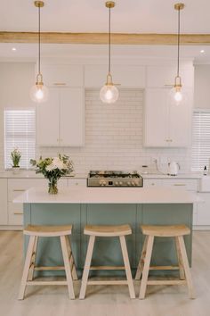 a kitchen with two stools next to an island