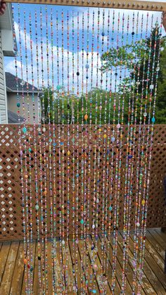 a wooden deck with beads hanging from it's side and a person standing next to it