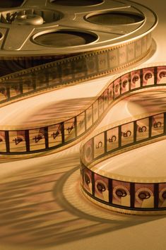 an old movie reel with film on the table next to it's side view