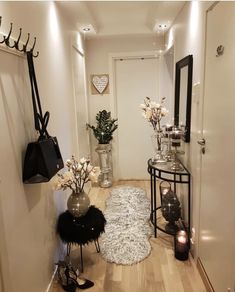 the hallway is clean and ready to be used as a place for shoes, vases and flowers