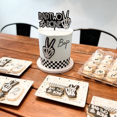 a wooden table topped with plates and cupcakes