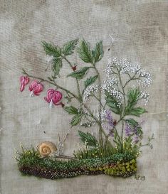 an embroidered piece of art with flowers and grass