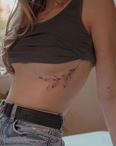 a woman with a leaf tattoo on her stomach