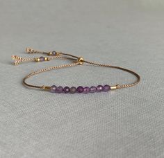 Beautiful dainty silk bracelet with lovely facetted violet Amthyst gemstones handstrung on silk cord. The bracelet is adjustable by using the sliding bead and comes lovely wrapped with card and meaning of the gemstone, a lovely gift ! Sophisticated and delicate on its own or combine it with other bracelets for a more Boho look AMETHYST symbolizes calmness, inner peace and mental clarity S I Z E : Bracelet opens up to 24 cm and nearly always fits, has to be shoven over your hand and is adjustable Adjustable Amethyst Beaded Bracelets With Birthstone, Adjustable Beaded Amethyst Bracelets, Adjustable Birthstone Beaded Bracelets For Friendship, Dainty Adjustable Birthstone Beaded Bracelets, Delicate Beaded Bracelet With Adjustable Chain, Purple Bracelets With Adjustable Chain, Purple Beaded Bracelets With Sliding Knot As Gift, Gift Purple Beaded Bracelets With Sliding Knot, Elegant Adjustable Friendship Bracelets With Faceted Beads