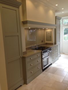 an empty kitchen with stainless steel appliances and tile flooring is seen in this image