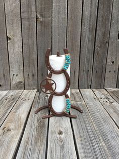 a white toilet paper roll holder with brown and turquoise beads on it sitting on top of a wooden table