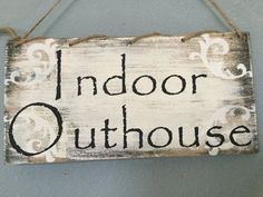 a sign that says indoor outhouse hanging on the wall