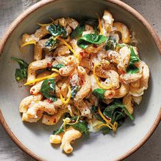 a white bowl filled with pasta and spinach