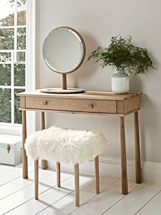 a wooden desk with a mirror and stool