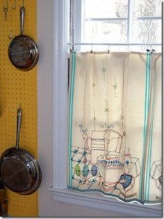 a kitchen window with pots and pans hanging on the hooks in front of it