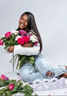 a woman sitting on the floor with flowers in front of her and numbers behind her