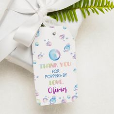 a gift tag with the words thank you for popping by love written on it next to a plant