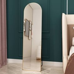 a large mirror sitting on top of a bed next to a white headboard and pillows