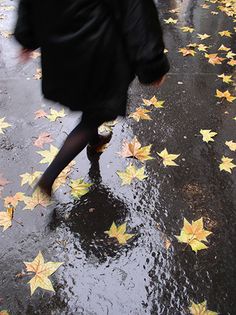 a woman walking in the rain with an umbrella over her head and stars on the ground