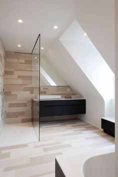 a bathroom with a sink, tub and shower in the middle of an atticed room