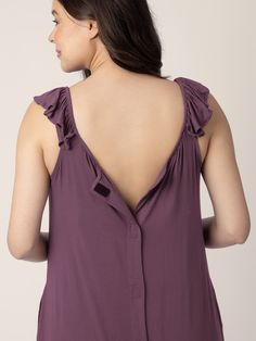 the back of a woman wearing a purple top with ruffles on her shoulders