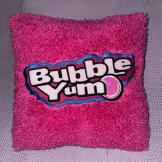 a pink pillow with the word bubble yum on it