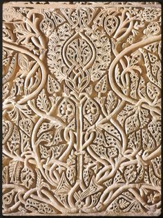 an intricately carved wall panel with vines and leaves on the outside, is shown