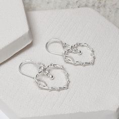 Our beautiful Sterling Silver Dangly Wire Heart Earrings are delicate yet delicious. These fantastic sterling silver earrings give a new and refreshing twist to the simple heart design. Made from fine sterling silver wire, these earrings are light enough to wear everyday and would not look out of place with any outfit. A perfect gift or young and old, friends, family or even yourself. All Martha Jackson jewellery comes complete with a gift box and blank gift card for you to write a short message on Made from Sterling Silver. Keep clean with an anti tarnish cloth. Dimensions overall length 3.1cm. Maximum width 1.9 cm Wire Heart Earrings, Simple Heart Design, Silver Wire Earrings, Aluminum Earrings, Wire Heart, Long Silver Earrings, Rose Quartz Earrings, Heart Drop Earrings, Dangly Earrings