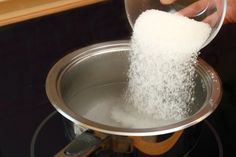 someone is pouring sugar into a pan on the stove