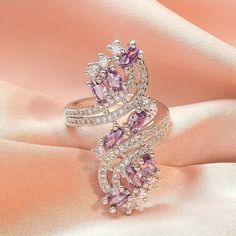 This stunning asymmetrical ring from Barbie Brides is the perfect gift for any occasion. The pear-shaped, lab-created amethyst stone shines beautifully in the white gold-plated copper setting, surrounded by excellent cut-grade cubic zirconia stones. The ring is nickel-free and features a bohemian-inspired design, making it both beautiful and comfortable to wear. Whether you're looking for an engagement ring, a Mother's Day gift, or a special Valentine's Day surprise, this luxury amethyst ring is sure to impress. Its purple and silver color scheme is both elegant and eye-catching, while its unique features make it a one-of-a-kind piece of fashion jewelry. Amethyst Ring Engagement, Zircon Ring, Copper Rings, Color Ring, Types Of Rings, Blue Crystals, San Valentino, Jewelry Trends, Womens Jewelry Rings