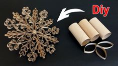 an ornament made out of toilet paper and rolled up with scissors next to it