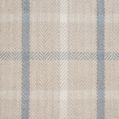 a beige and blue checkered rug on top of a wooden floor with an area rug underneath it