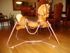 a wooden rocking horse sitting on top of a hard wood floor