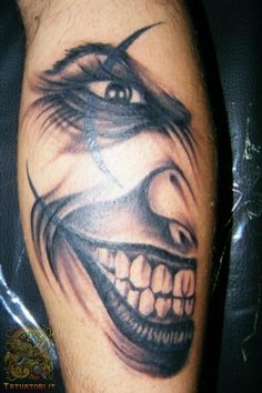 a close up of a person's arm with a tattoo on it and an evil face