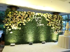 a table with a cake and flowers on it in front of a wall that says happy new year