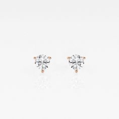 two tone gold and white diamond earrings on a white background with reflection in the middle