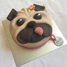 a cake shaped like a pug with a name tag on it