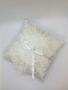 a white ring pillow with a ribbon on it