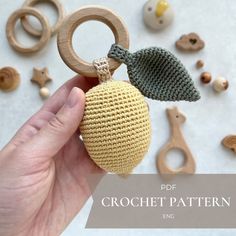 a hand holding a crochet pattern for an apple ornament