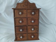 an old wooden drawer with six drawers and four eyeballs on the bottom, sitting on a white sheet