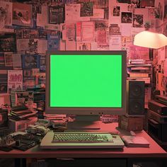 a desktop computer with a green screen in front of a wall full of books and papers