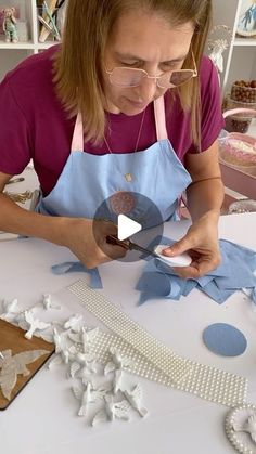 a woman in an apron is working on some decorations