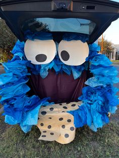 a car trunk decorated with blue tissue paper and black polka dots, has an evil face on it