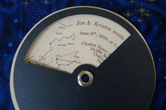 a close up of a clock on a blue surface with stars in the sky behind it