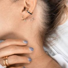 a close up of a person wearing ear rings and piercings on her left ear