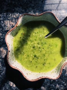 a bowl filled with green liquid on top of a table