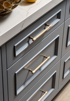 an image of a kitchen counter top with gold handles and knobs on the drawers