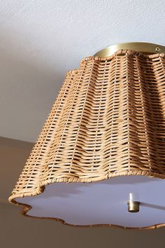 a wicker lamp shade hanging from the ceiling