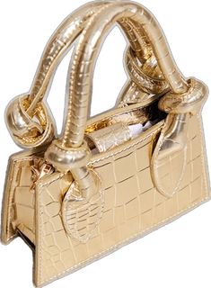 a gold purse that is on top of a white surface and has an attached handle