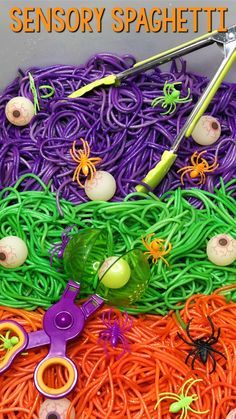 an assortment of spooky toys and scissors are on top of the halloween noodles