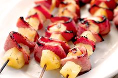 the skewers are covered with meat and pineapples on toothpicks