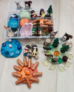 a plastic container filled with lots of toys and figurines on top of a wooden table