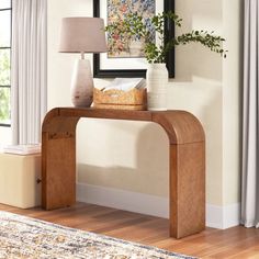 a wooden console table with a basket on top and a lamp next to it in a living room